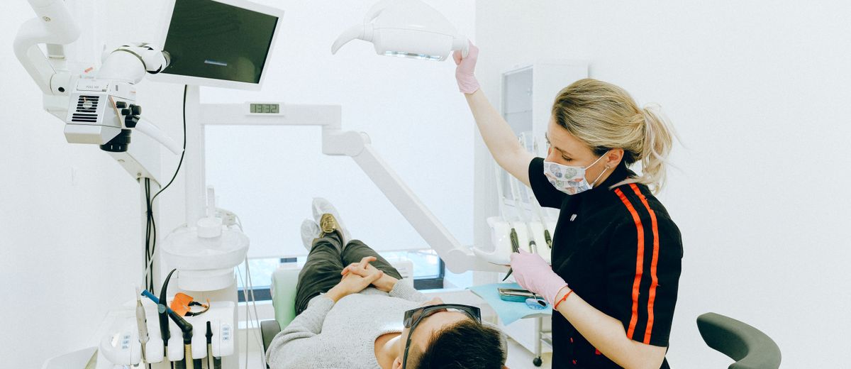 Recepcionista de clínica dental atendiendo a un paciente con amabilidad